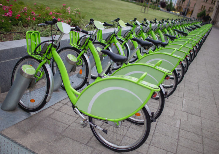 Row of new green public sharing bicycle lined up on the street , Modern concept of ecological transportation, Bike urban transport